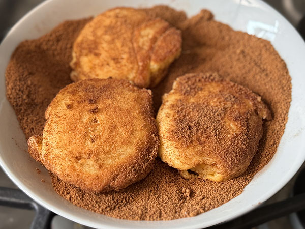 Apple donut pancakes dipped in cinnamon sugar mixture.