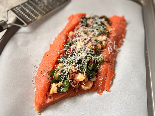 Parmesan grated on top of the shrimp, sun-dried tomatoes and spinach filling.
