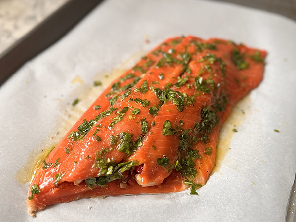 Closed stuffed salmon fillet brushed with ghee and parsley mixture.