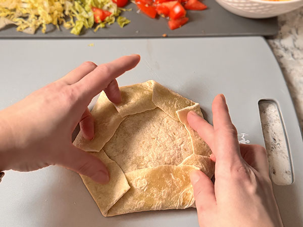 Photo instruction on how to fold the edges of the tortilla to create a beautiful wrap.