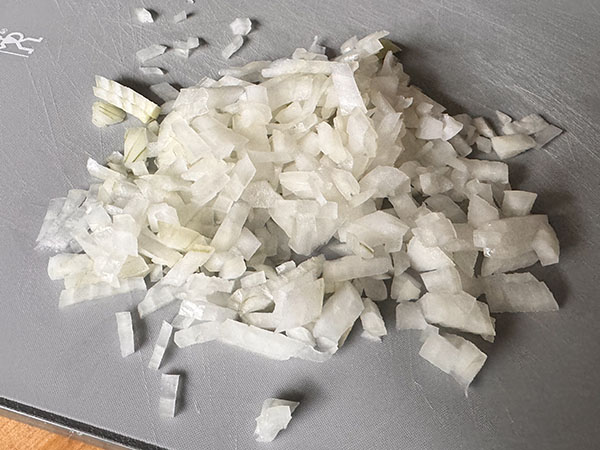Chopped raw onion on a cutting board.