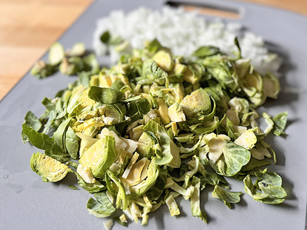 Sliced Brussels sprouts on a cutting board.