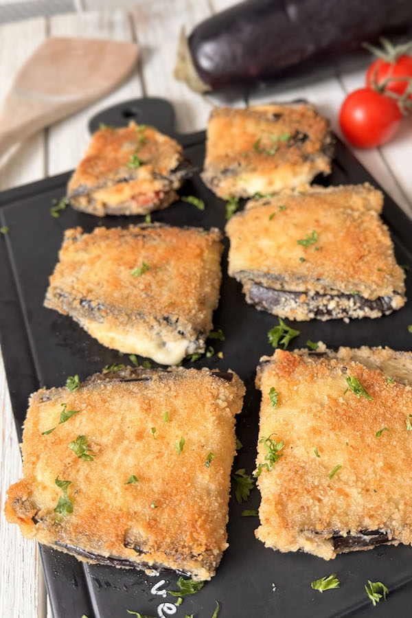 Crispy Breaded Eggplant Pockets with Tomato and Mozzarella on a serving board.