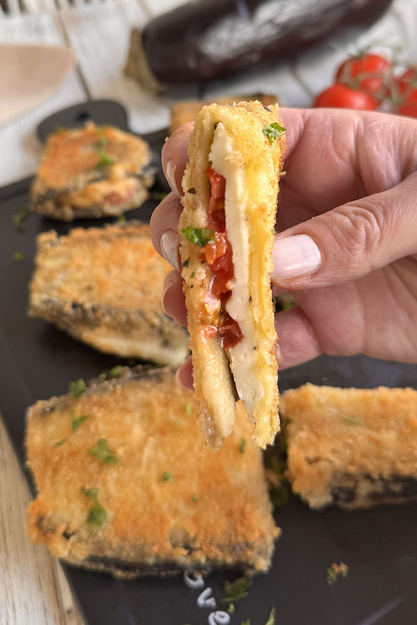 Crispy Breaded Eggplant Pocket with Tomato and Mozzarella cut in half to show the filling.
