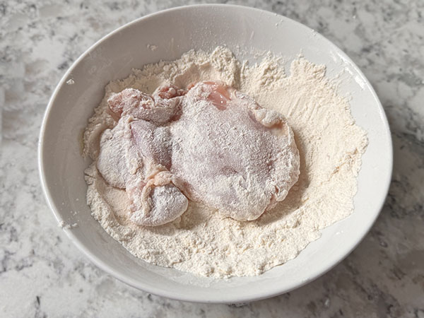 Boneless skinless chicken thigh coated in flour.