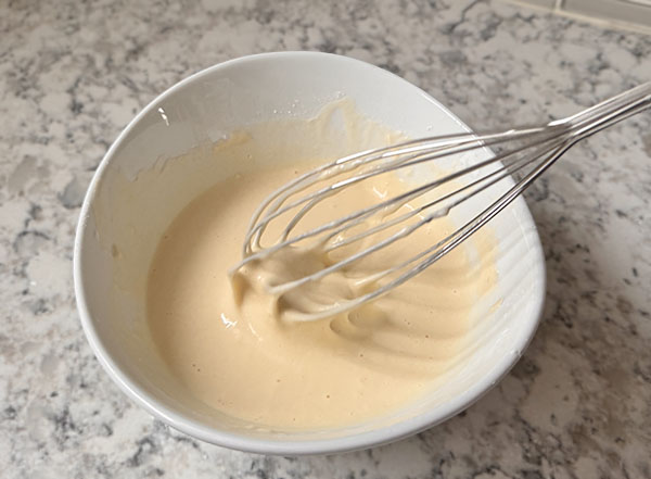 Tempura batter mixed in a bowl for dipping shrimp.