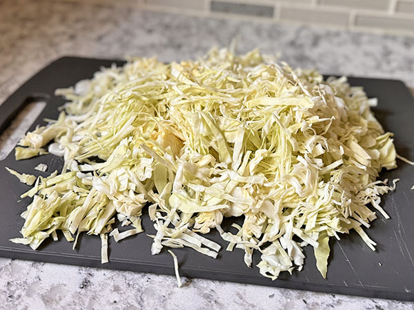 Shredded cabbage on a cutting board.