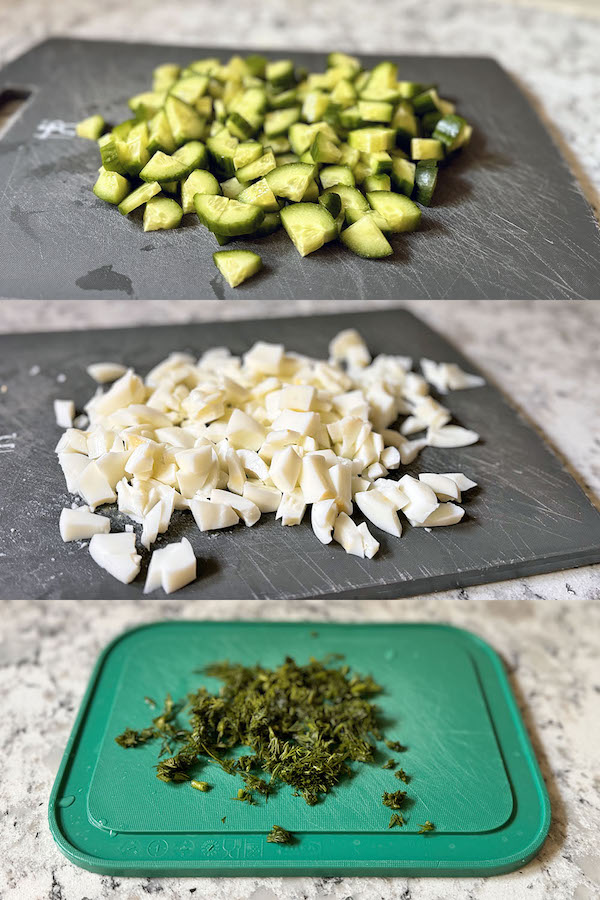 Diced cucumbers, chopped egg whites and dill on separate cutting boards.