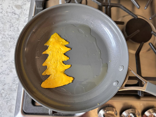Christmas tree drawn on skillet using egg yolks.