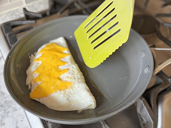 Folded omelette with filling inside and egg yolks Christmas tree on top.