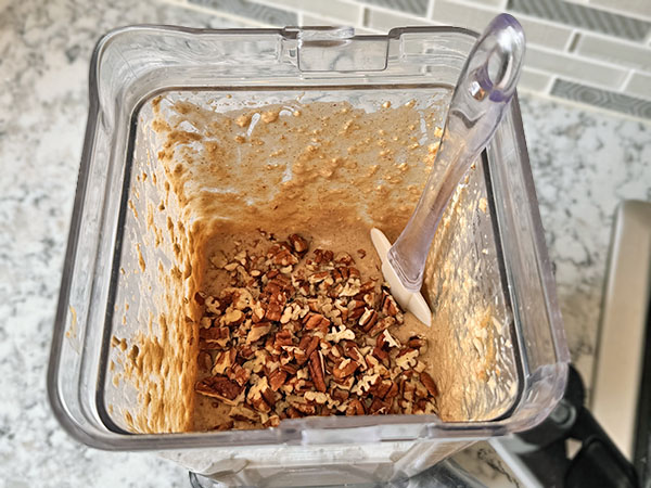 Chopped pecans on top of blended muffin batter.