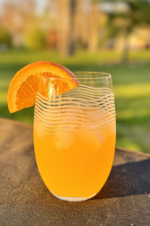 Orange Moscow Mule with Bacardi Rum, in a glass, garnished with a slice of orange.