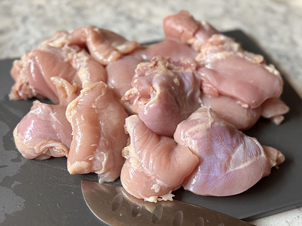 Skinless boneless chicken thighs cut in half.