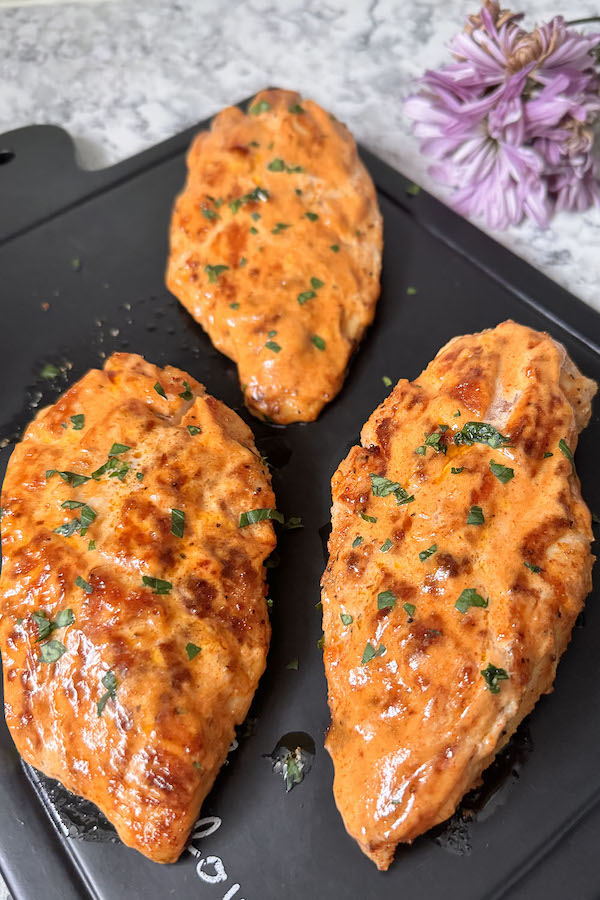 Pan Fried Chicken Breasts brushed with a Quick Dipping Sauce on a serving board.
