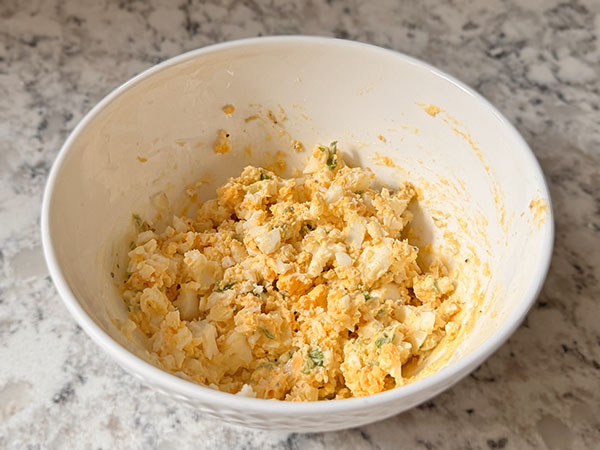 Mashed egg salad in a bowl.