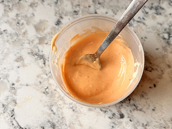 Homemade quick spicy mayo in a cup.